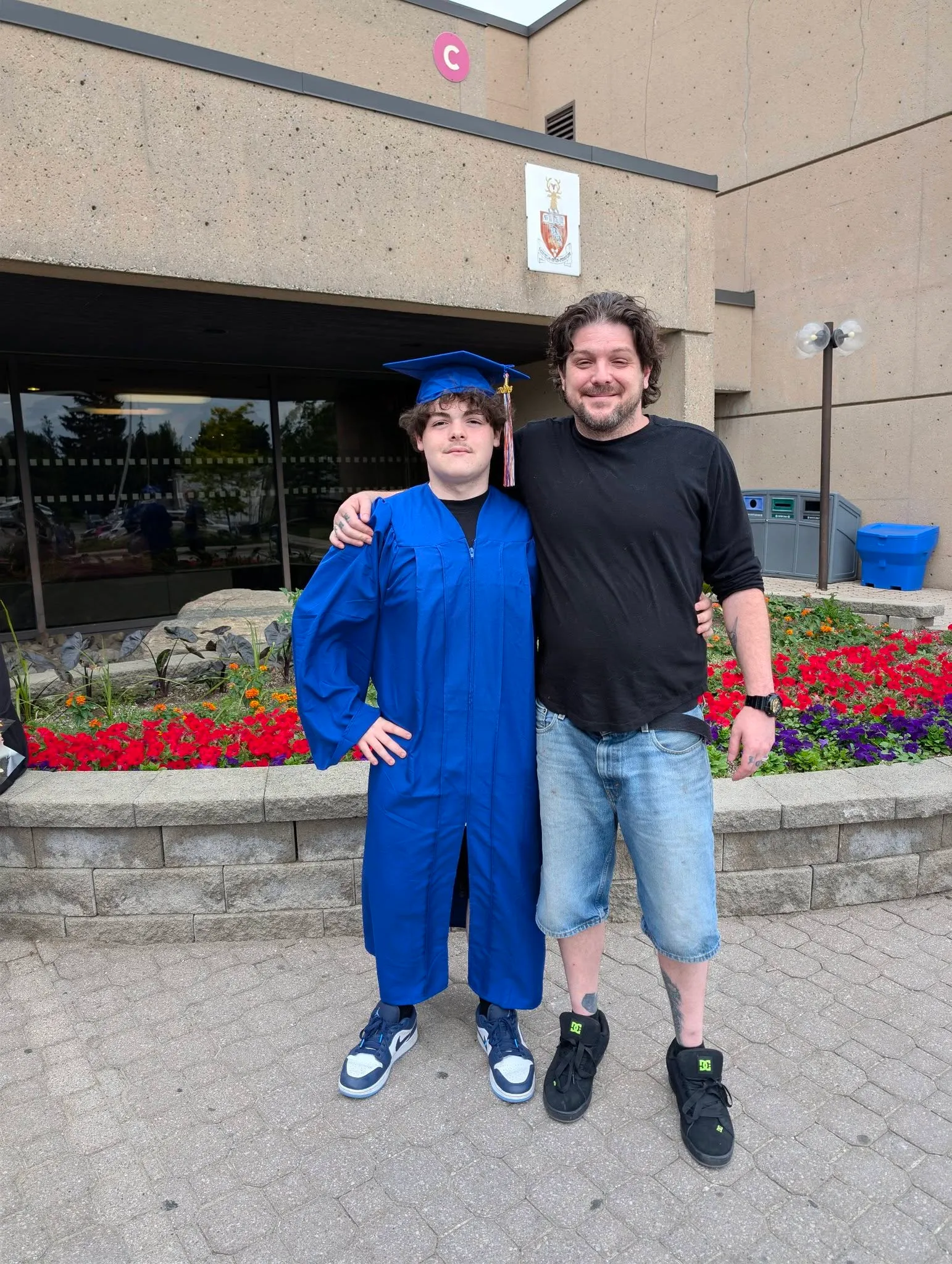 Ian with his son, in cap and gown, at his son's graduation